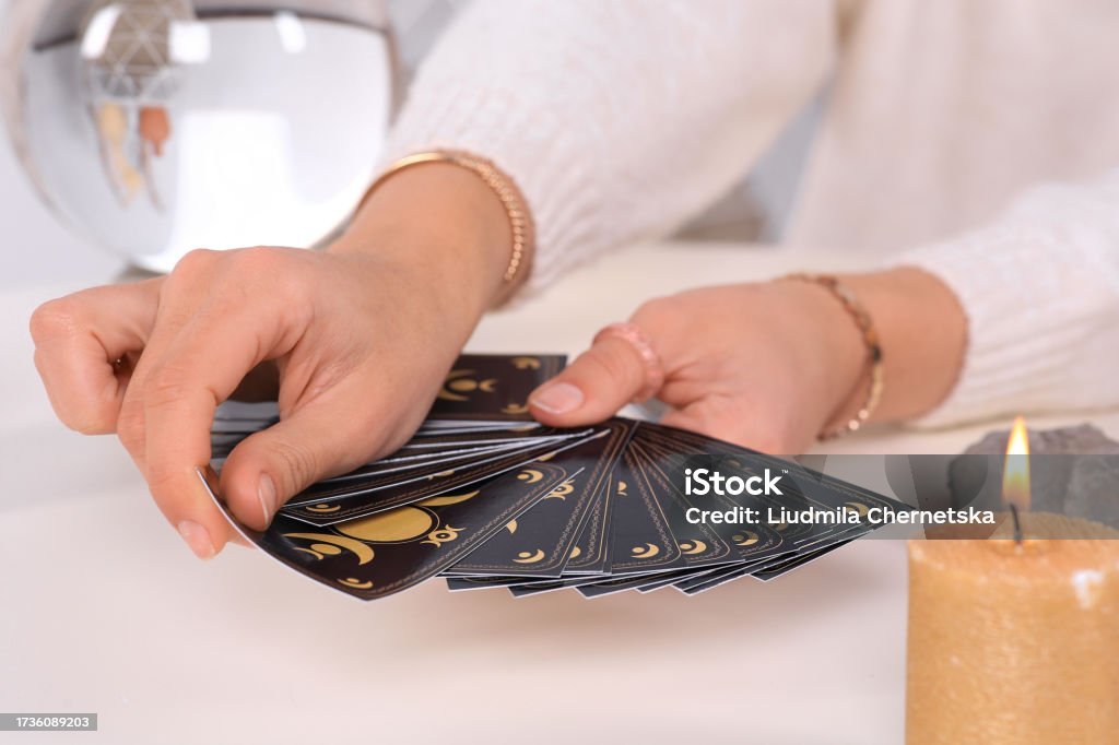 Soothsayer pulling one tarot card at table, closeup. Future telling